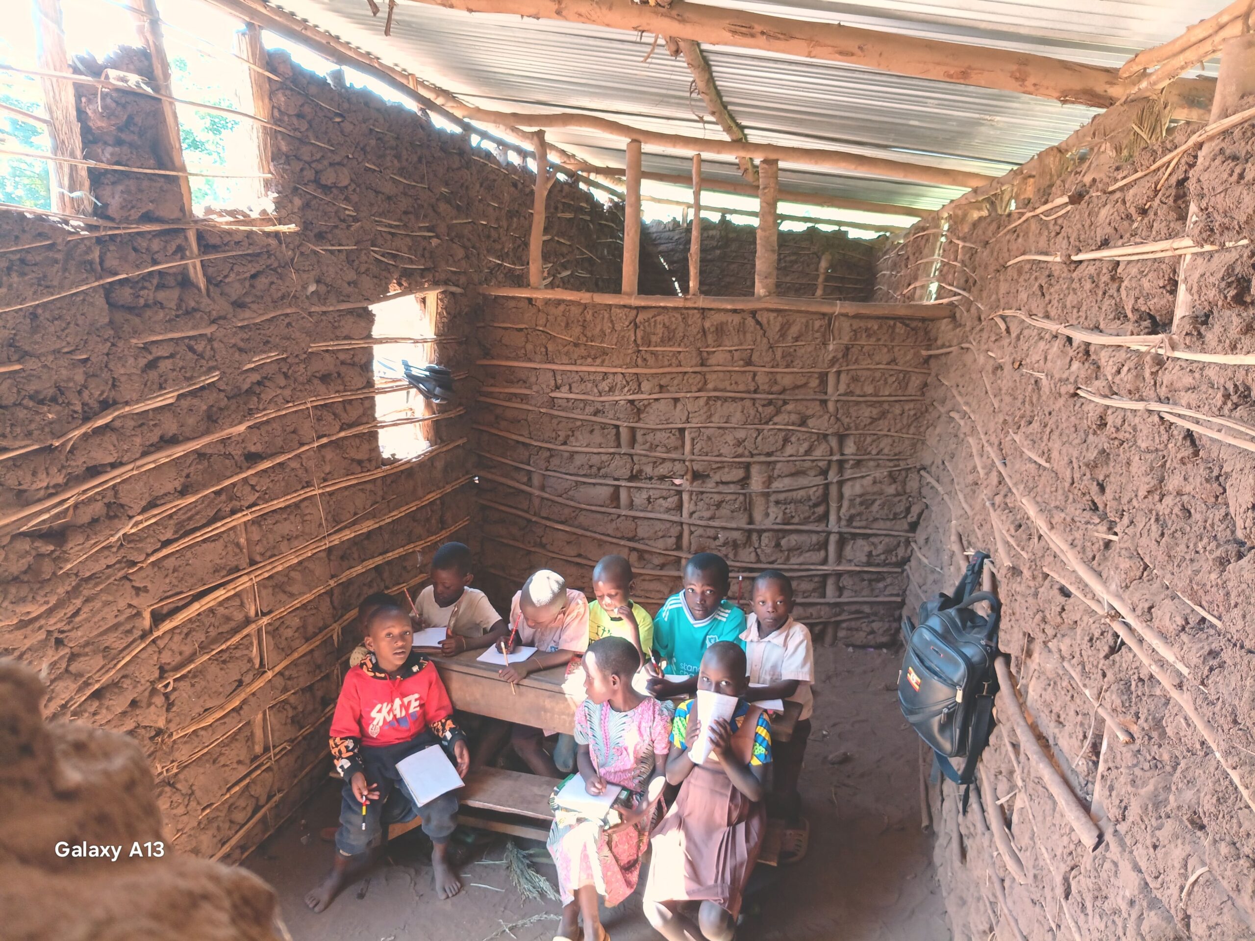 Children studying together inside a rural classroom in Kifumbira, Uganda