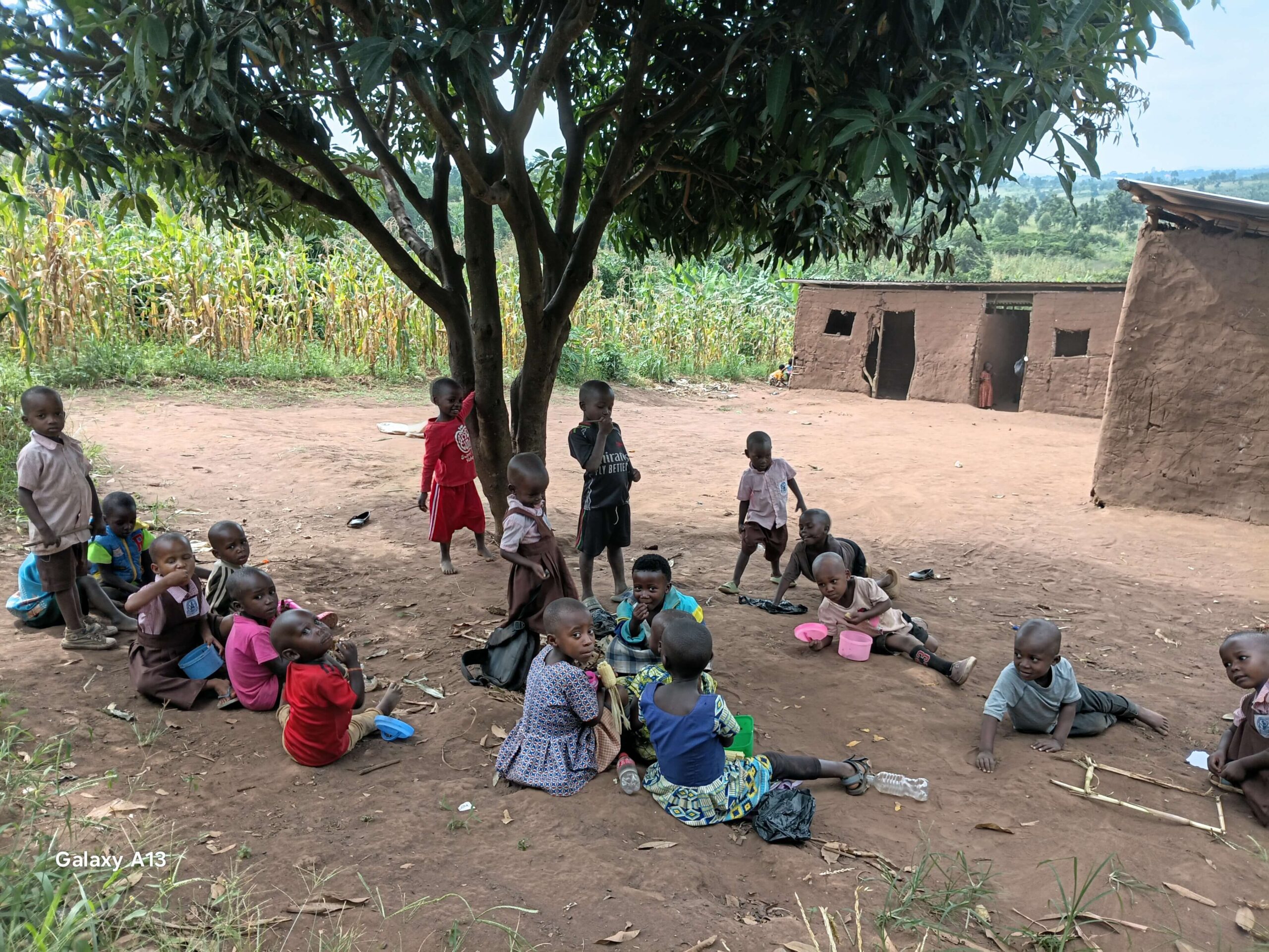 Children gathered together under a tree in Kifumbira, Mubende District, Uganda