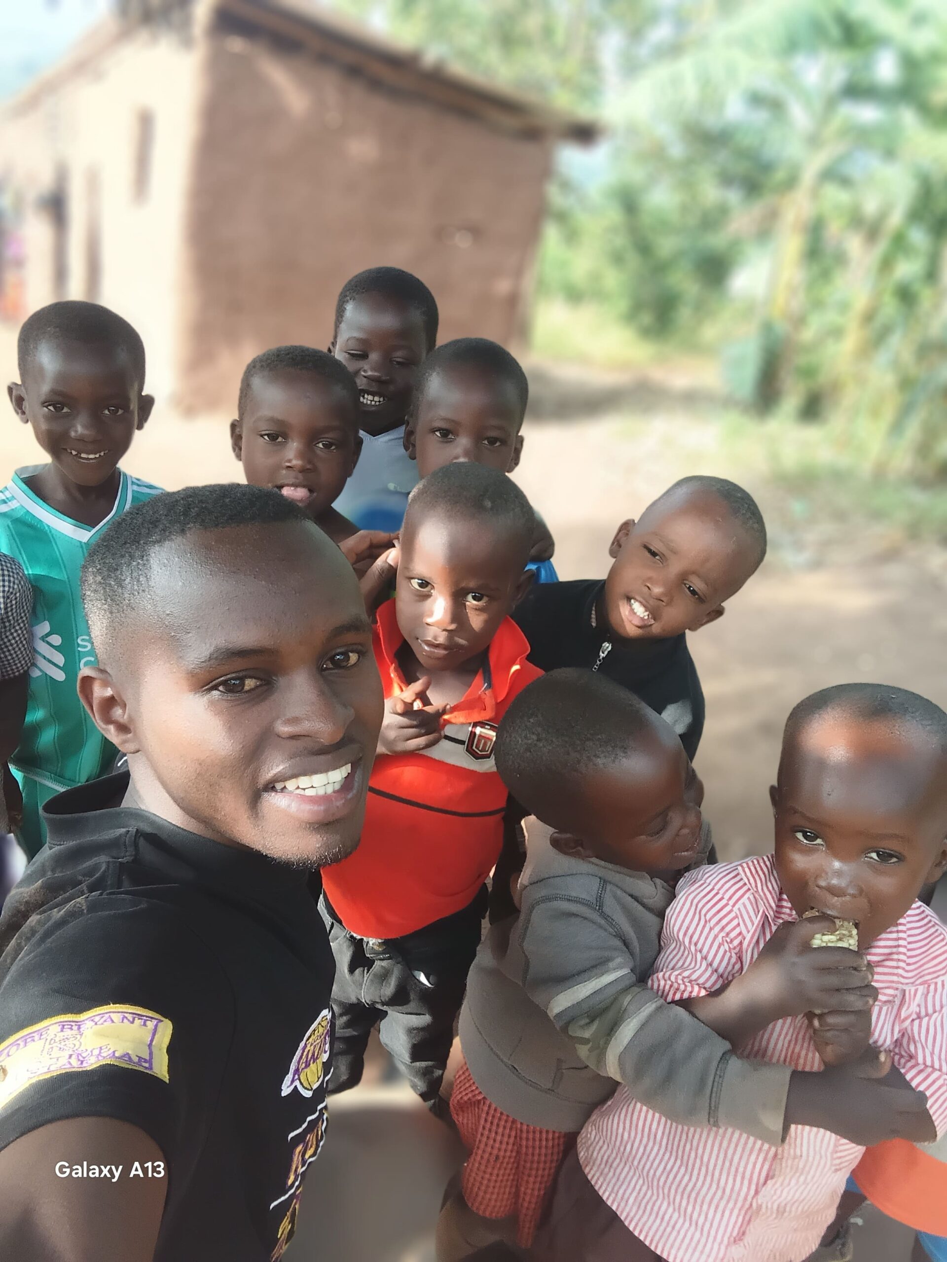 Muccunguzi Bosco with children in Kifumbira community, Uganda